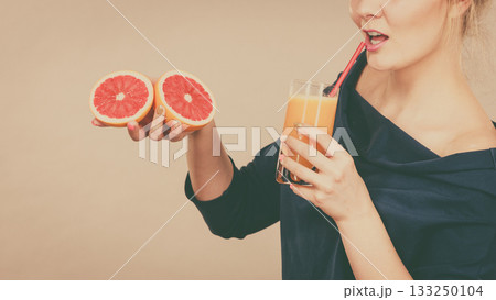 Happy woman holding fresh orange juice Happy woman holding fresh orange juice 133250104
