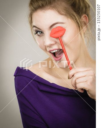 Happy woman holding lips on stick Happy woman holding lips on stick 133250107