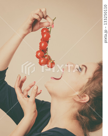 Woman holding fresh cherry tomatoes Woman holding fresh cherry tomatoes 133250110