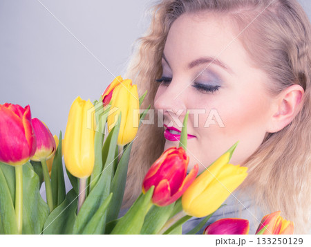 Pretty woman with red yellow tulips bunch Pretty woman with red yellow tulips bunch 133250129