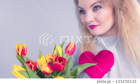 Woman holds tulips and red heart 133250132