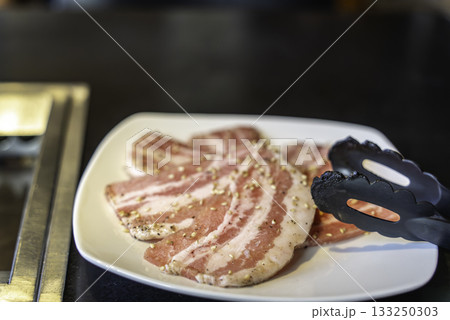 焼肉屋で豚バラ肉を焼く 焼肉屋で豚バラ肉を焼く 133250303