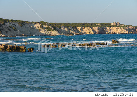 Serene coastal landscape with gentle waves lapping against rocky shores during golden hour. Serene coastal landscape with gentle waves lapping against rocky shores during golden hour. 133250413