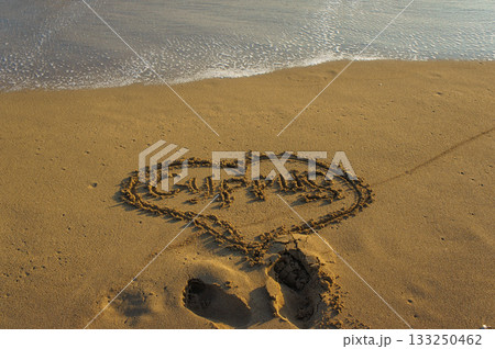Messages of love written in the sand at sunset by the tranquil shoreline. Messages of love written in the sand at sunset by the tranquil shoreline. 133250462