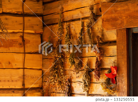 Medicinal plants hang in a village hut for health. Bunches of dried herbs: thyme, calendula, nettle, and chamomile. A folk herbal pharmacy, close-up 133250555