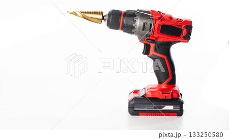 Modern red drill screwdriver with step drill bit in keyless chuck on white background, close-up Modern red drill screwdriver with step drill bit in keyless chuck on white background, close-up 133250580