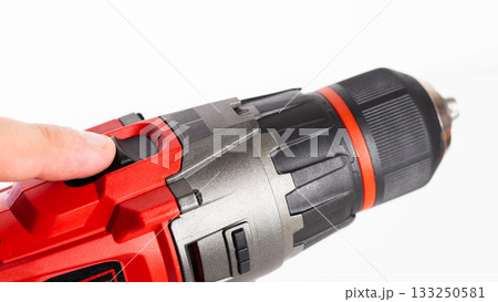 Switch in a modern screwdriver on a drill, close-up. White background, isolate, industry 133250581