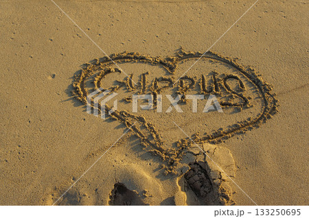 A heart drawn in sand with the word \'CYPRUS\' at a serene beach during sunset. 133250695