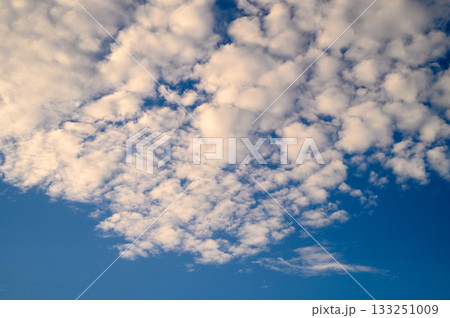 Fluffy white clouds drift across a bright blue sky on a serene afternoon Fluffy white clouds drift across a bright blue sky on a serene afternoon 133251009