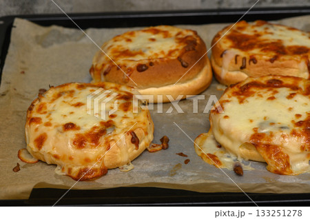 Melting cheese and savory toppings create a mouthwatering delight in an oven-baked dish 133251278
