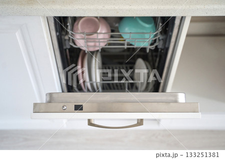 Open dishwasher with clean plates and bowls in kitchen setting Open dishwasher with clean plates and bowls in kitchen setting 133251381