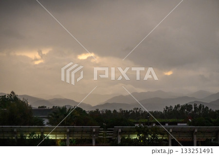 Dramatic twilight sky over mountains hints at a coming storm in a tranquil landscape 133251491
