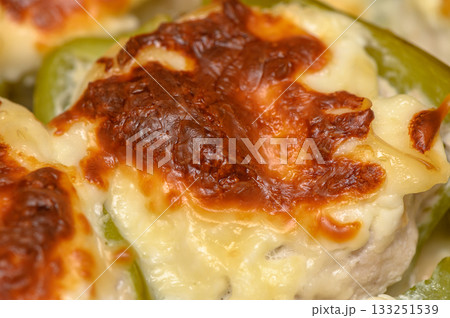 Cheese-topped stuffed bell peppers baked to golden perfection during a cozy evening gathering Cheese-topped stuffed bell peppers baked to golden perfection during a cozy evening gathering 133251539