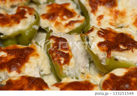 Creamy stuffed peppers bake to golden perfection in a cozy kitchen filled with savory aromas Creamy stuffed peppers bake to golden perfection in a cozy kitchen filled with savory aromas 133251549