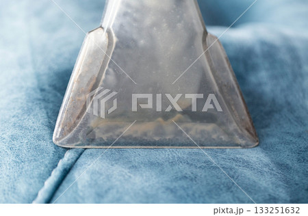 Cleaning process for upholstery with a vacuum tool, showing detail of the suction head in action on a soft surface 133251632