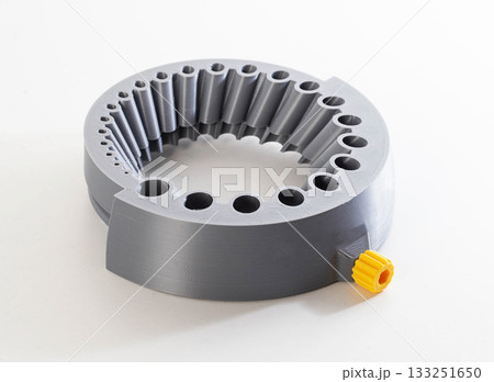 A gray round tool with holes of different sizes for sharpening drills through a grinder, close-up A gray round tool with holes of different sizes for sharpening drills through a grinder, close-up 133251650