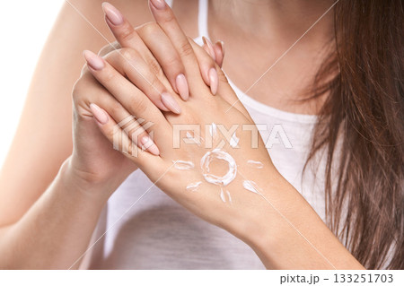 Female with sun-shaped lotion on caucasian hand promoting skincare and sun 133251703