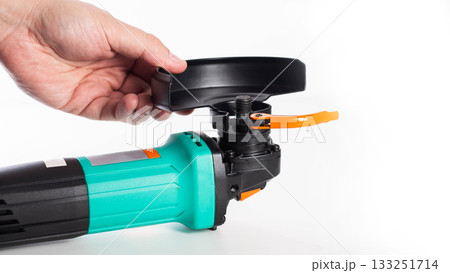 Installing the protective cover on a new grinder before use. Safety precautions, white background, isolated. Copy space for text, close-up 133251714