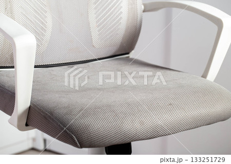 Dirty gray upholstery fabric with stains on computer chair before dry cleaning, close-up 133251729