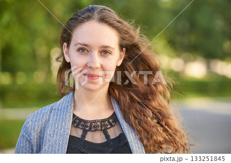 Young caucasian female with long brown hair smiling outdoors in natural setting Young caucasian female with long brown hair smiling outdoors in natural setting 133251845