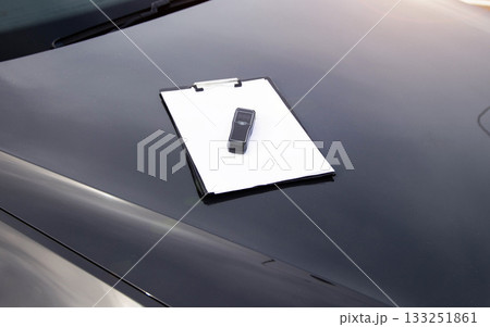 Breathalyzer And Clipboard With Blank Paper On Car Hood. Equipment For Documenting Alcohol Test. Driving license revocation for alcohol 133251861