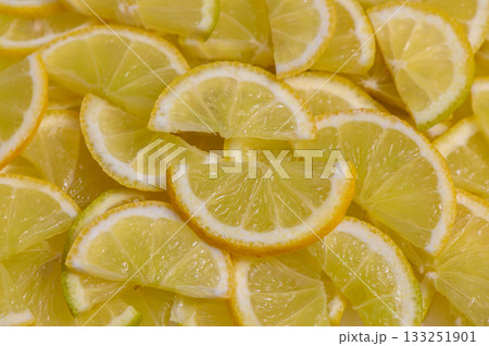Freshly sliced lemons arranged beautifully on a vibrant surface for culinary use and decoration Freshly sliced lemons arranged beautifully on a vibrant surface for culinary use and decoration 133251901
