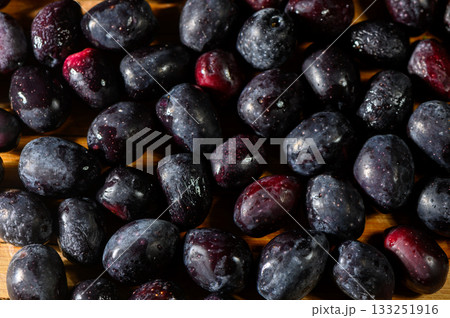 Freshly harvested plums arranged artfully on a wooden surface ready for culinary delight Freshly harvested plums arranged artfully on a wooden surface ready for culinary delight 133251916