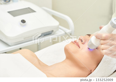 Female caucasian adult receiving facial treatment with modern skin care 133252009