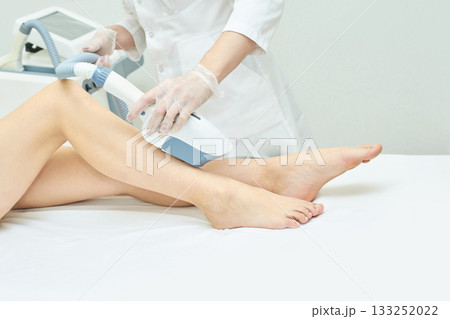 Laser hair removal treatment on female legs by medical professional in clinic 133252022