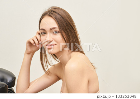 Young caucasian female with long brown hair smiling in neutral background Young caucasian female with long brown hair smiling in neutral background 133252049
