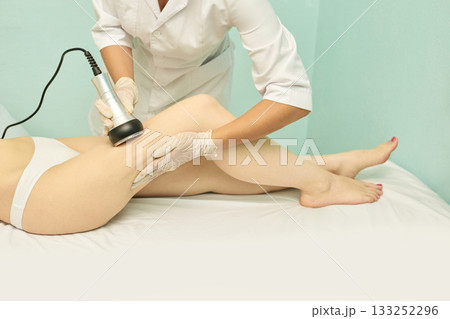 Female undergoing ultrasound cavitation therapy for cellulite reduction in spa Female undergoing ultrasound cavitation therapy for cellulite reduction in spa 133252296