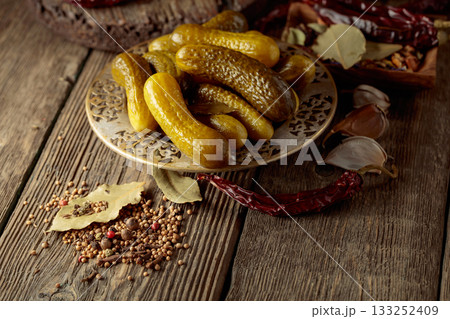 Pickled cucumbers with ingredients on an old wooden table. 133252409
