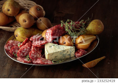 Dry-cured sausages, blue cheese, thyme and pears. Dry-cured sausages, blue cheese, thyme and pears. 133252419