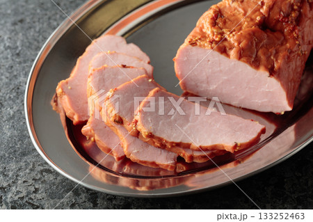 Delicious smoked ham on a metal tray. Delicious smoked ham on a metal tray. 133252463