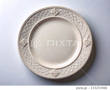 Classic elegance. Ceramic plate with a classic white design and floral border on a white background. Porcelain kitchenware. Close-up. Top view. 133253466