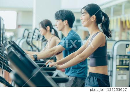 スポーツジムでアップライトバイクを使う男女 133253697