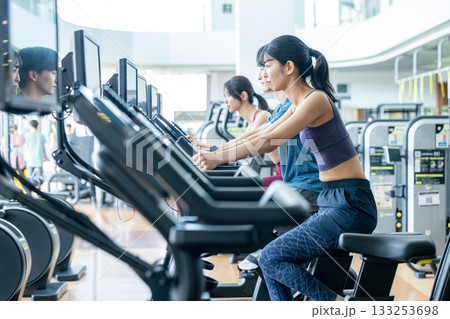 スポーツジムでアップライトバイクを使う男女 133253698