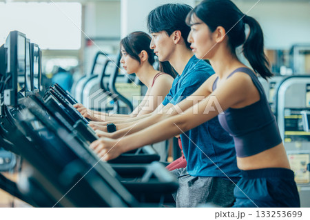 スポーツジムでアップライトバイクを使う男女 133253699