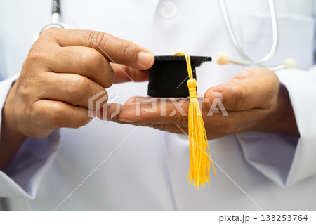 Asian woman doctor holding graduation hat in hospital, Medical education. Asian woman doctor holding graduation hat in hospital, Medical education. 133253764