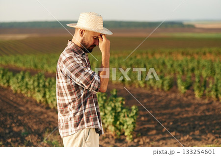 Tired, feeling bad. Farmer is on the agricultural field Tired, feeling bad. Farmer is on the agricultural field 133254601