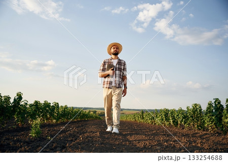 Front view, walking forward. Farmer is on the agricultural field 133254688
