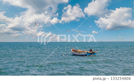 Fishing boat, calm sea, clear blue sky, white clouds, sunlight reflection, copy space left, realistic water texture, distant horizon, seagulls flying, gentle waves. 133254808