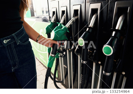 Focused detailed close up view. Young woman on the gas station Focused detailed close up view. Young woman on the gas station 133254964