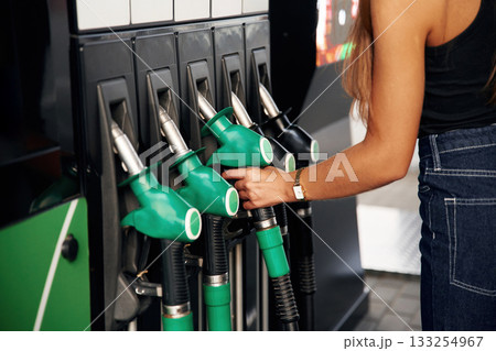 Focused detailed close up view. Young woman on the gas station 133254967