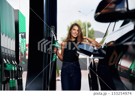Ready to refill the automobile. A young woman at a gas station with her car Ready to refill the automobile. A young woman at a gas station with her car 133254974