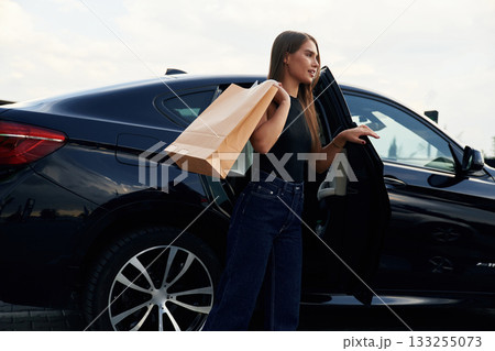 Right after the shopping. Woman is near her car outdoors 133255073