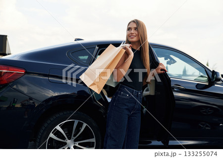 Right after the shopping. Woman is near her car outdoors Right after the shopping. Woman is near her car outdoors 133255074