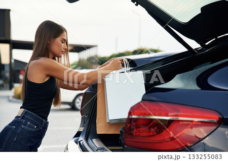 Woman is near her car outdoors 133255083