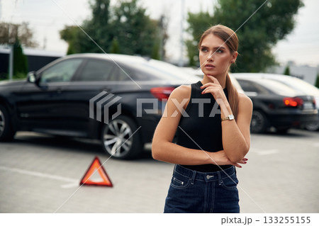 Woman's car is broken, accident, standing outdoors Woman's car is broken, accident, standing outdoors 133255155