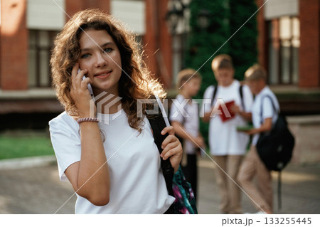 Standing and posing. Kids are near the school together, pupils Standing and posing. Kids are near the school together, pupils 133255445